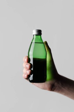 Su şişesi Mock-Up - erkek gri bir arka plan üzerinde bir su şişesi tutan eller