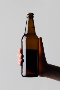 Bira şişe Mock-Up-gri bir arka plan üzerinde bir bira şişesi holding erkek eller
