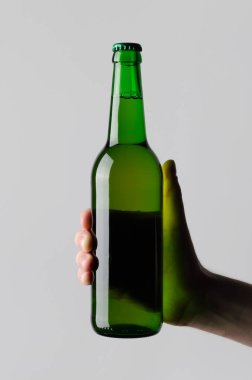 Bira şişe Mock-Up-gri bir arka plan üzerinde bir bira şişesi holding erkek eller