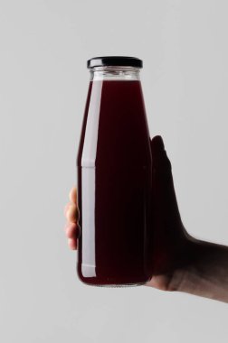 Suyu şişe Mock-Up-gri bir arka plan üzerine suyu şişesi holding erkek eller