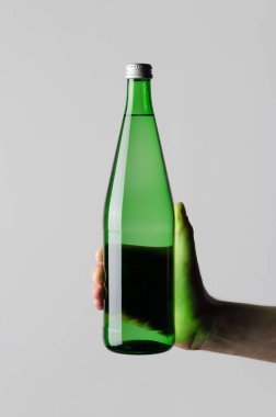 Su şişesi Mock-Up - erkek gri bir arka plan üzerinde bir su şişesi tutan eller