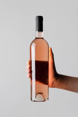 Şarap şişesi Mock-Up-gri bir arka plan üzerinde bir şarap şişesi holding erkek eller