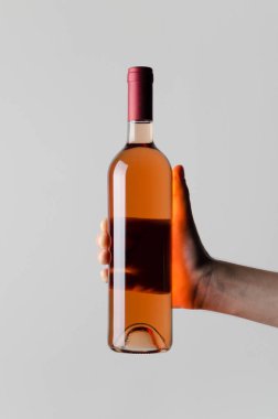 Şarap şişesi Mock-Up-gri bir arka plan üzerinde bir şarap şişesi holding erkek eller