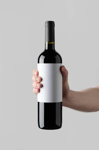 Wine Bottle Mock-Up. Blank Label - Male hands holding a wine bottle on a gray background