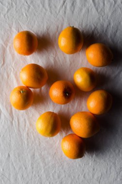 Portakal beyaz keten masa örtüsü üzerinde.