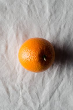 Turuncu beyaz keten masa örtüsü üzerinde.