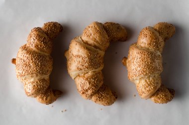 Beyaz parşömen kağıt üzerine taze kruvasanlar.