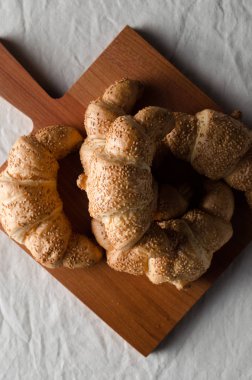 Beyaz keten masa örtüsü üzerinde taze kruvasanlar.