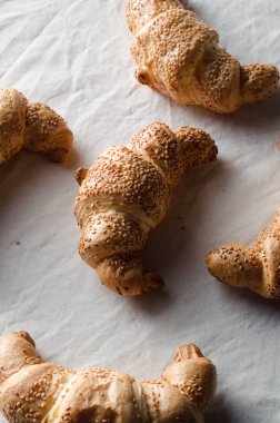 Beyaz keten masa örtüsü üzerinde taze kruvasanlar.