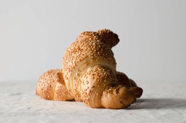 Beyaz keten masa örtüsü üzerinde taze kruvasanlar.