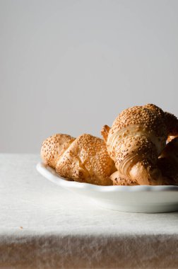 Beyaz keten masa örtüsü üzerinde taze kruvasanlar.