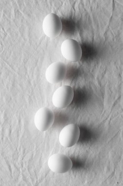 Bir beyaz keten masa örtüsü arka plan üzerinde beyaz yumurta.