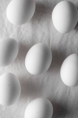 Bir beyaz keten masa örtüsü arka plan üzerinde beyaz yumurta.