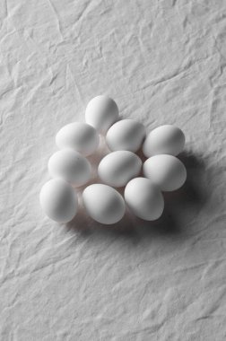 Bir beyaz keten masa örtüsü arka plan üzerinde beyaz yumurta.