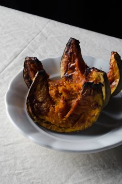 Kavrulmuş kabak dilimleri üzerinde beyaz keten masa örtüsü.