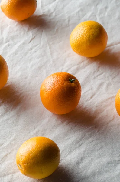 Portakal beyaz keten masa örtüsü üzerinde.