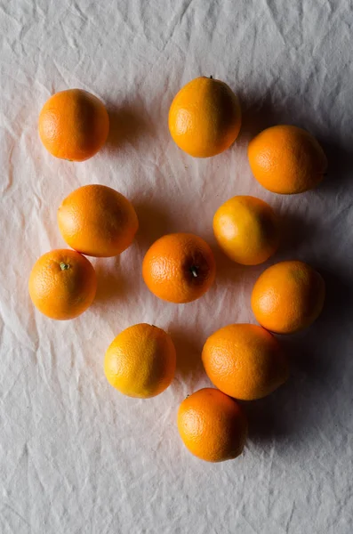 Portakal beyaz keten masa örtüsü üzerinde.