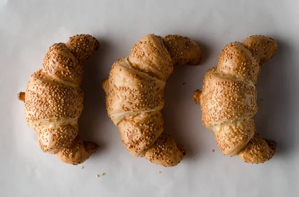 Beyaz parşömen kağıt üzerine taze kruvasanlar.