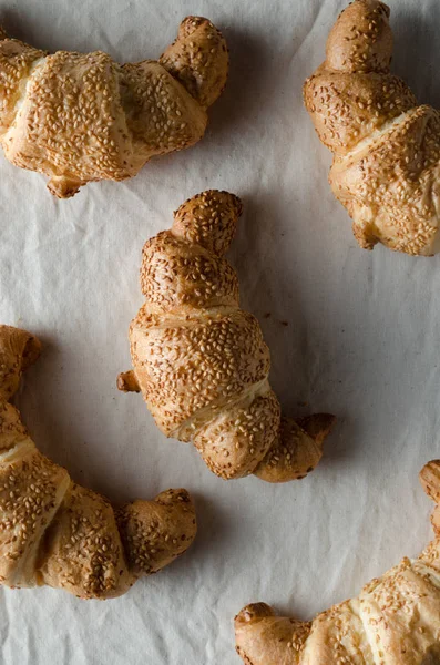 Beyaz keten masa örtüsü üzerinde taze kruvasanlar.