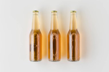 Üç bira şişesi mockup üst görünümü.