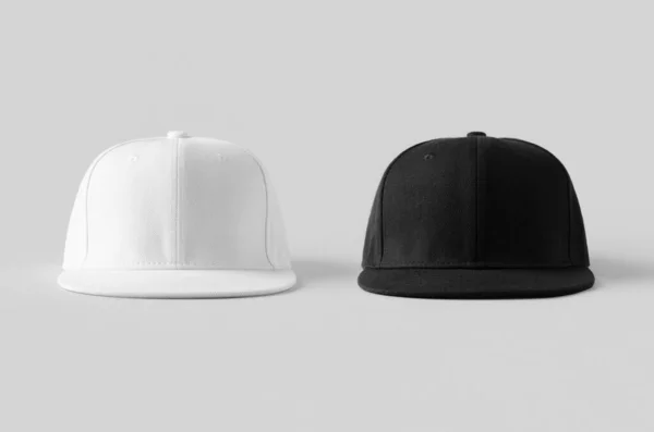 Gri arkaplanda beyaz ve siyah snapback modelleri, ön manzara.