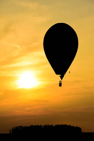 Varmluftsballonger i skyn som flyger vid solnedgången — Stockfoto
