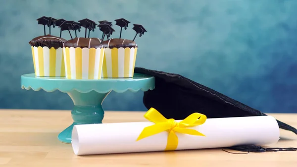 Cupcake per feste di laurea a tema giallo e blu con cappelli cap toppers . — Foto Stock
