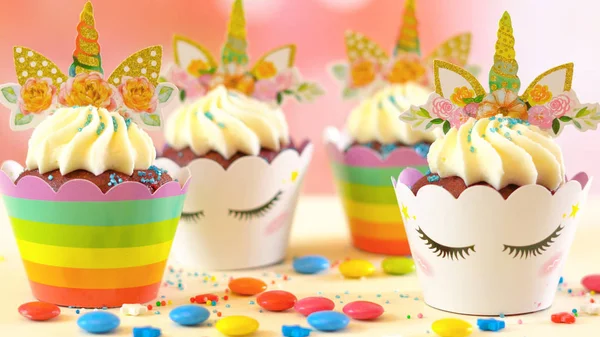 Decorating childrens birthday party unicorn themed cupcakes, closeup. — Stock Photo, Image