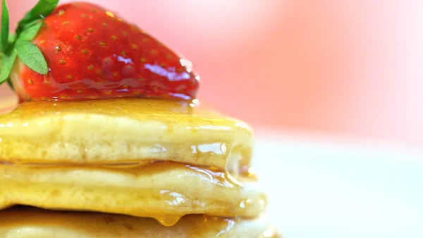 Frittelle con fragola sulla parte superiore e condito con sciroppo, macro primo piano . — Foto Stock