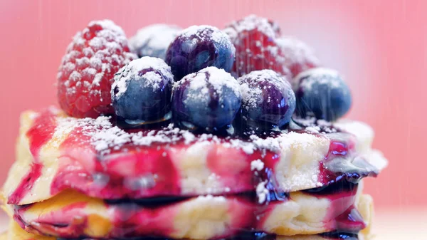 Pancakes with berries and drizzled with blueberry maple syrup, macro closeup. — Stock Photo, Image