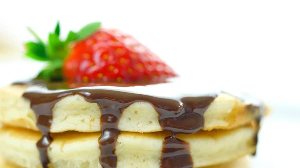 Pannenkoeken met aardbeien en besprenkeld met chocoladesaus, macro close-up. — Stockfoto