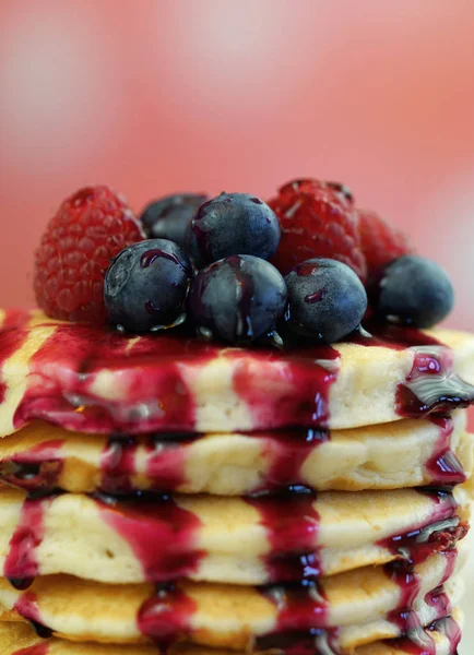 Pancakes with berries and drizzled with blueberry maple syrup, macro closeup. — Stock Photo, Image