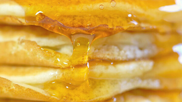 Pancakes drizzled with syrup, macro closeup. Royalty Free Stock Images