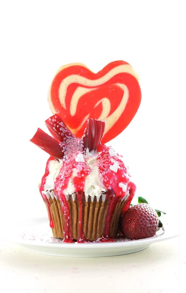 Bunte Neuheit Cupcake mit Bonbons und großen herzförmigen Lutscher dekoriert — Stockfoto
