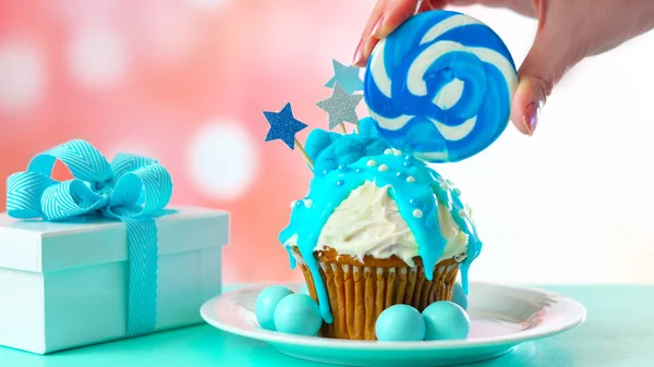 Синий кекс, украшенный конфетами и большими леденцами . — стоковое фото