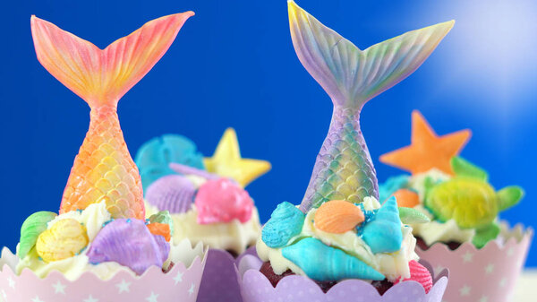 Mermaid theme cupcakes with colorful glitter tails, shells and sea creatures.