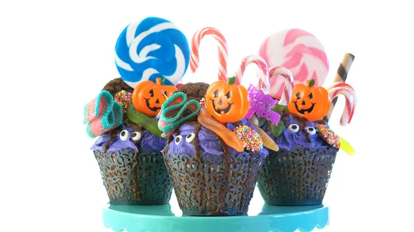 Halloween candyland gotejamento bolo estilo cupcakes com pirulitos e doces em branco . — Fotografia de Stock