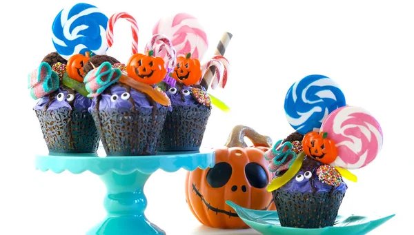 Halloween candyland druppelen taart stijl cupcakes met lollies en snoep op wit. — Stockfoto
