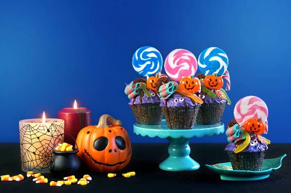 Halloween candyland dropp tårta stil cupcakes med godis på blå bakgrund. — Stockfoto