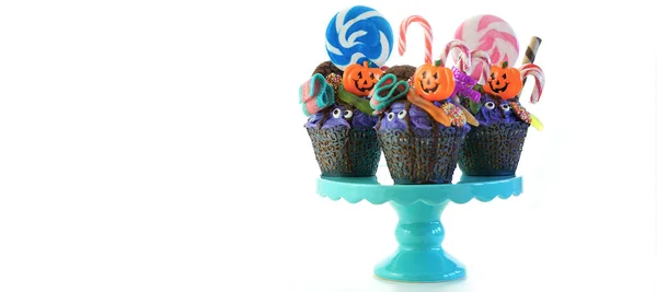 Halloween candyland odkapávací dort stylu cupcakes s lízátka a bonbóny na bílém. — Stock fotografie