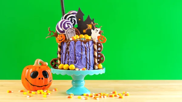 På trend Halloween candyland nyhet droppa kaka mot grön bakgrund. — Stockfoto