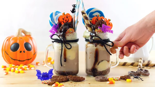 On-trend Halloween freak shakes decorated with candy, cookies and lollipops. — Stock Photo, Image