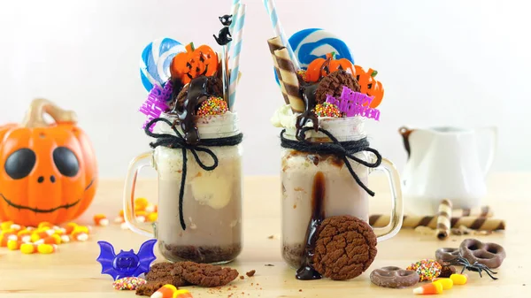 Sur la tendance Halloween freak shakes décoré avec des bonbons, biscuits et sucettes . — Photo