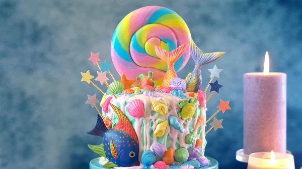 Gâteau de bonbons thème sirène avec des queues de paillettes, coquillages et créatures marines . — Photo