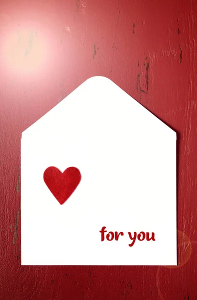 Valentines Day list koperty na czerwonym tle. z Flara obiektywu. — Zdjęcie stockowe