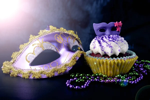 Cupcakes Mardi Gras con decoración de mascarillas, con destello de lente . —  Fotos de Stock