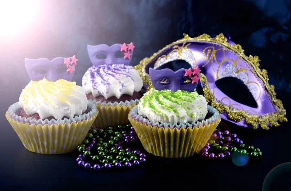 Cupcakes Mardi Gras con decoración de mascarillas, con destello de lente . —  Fotos de Stock