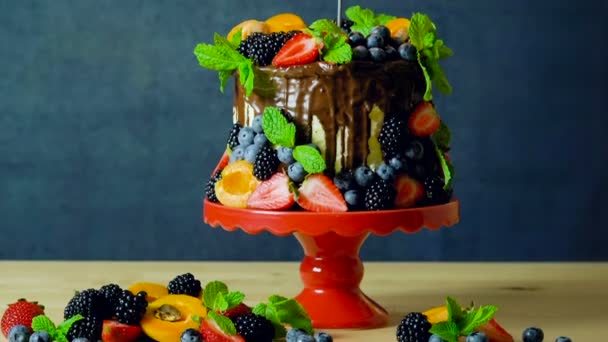 Delicious chocolate drip cake decorated with fresh seasonal fruit and berries. — Stock Video