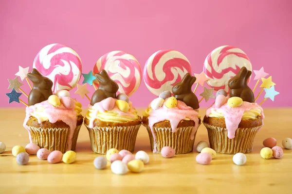 Pascua tema caramelo tierra goteo cupcakes en partido mesa ajuste . — Foto de Stock