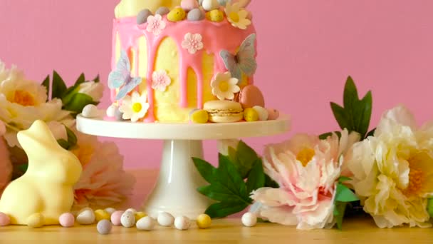 Velikonoční candyland odkapávat dort s bílé čokoládové bunny v stranu prostírání. — Stock video